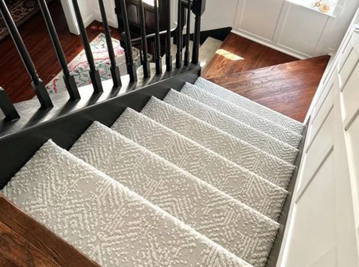 stairs with patterned carpet and dark hardwood floors